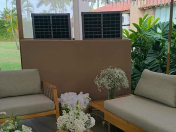 Dois climatizadores atrás dos sofás e arranjos de flores do casamento Ana e Jonas.
