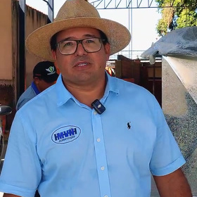 Representante da MVN com chapéu, óculos e camisa azul com a marca da empresa.